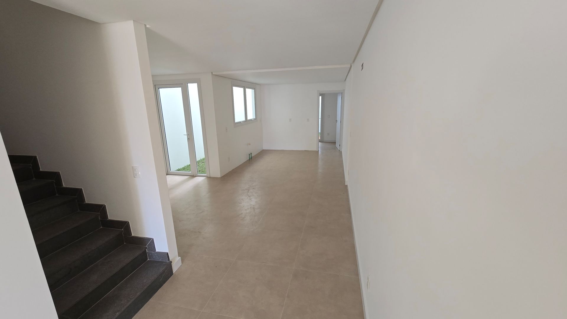 Hall com escada e living ao fundo